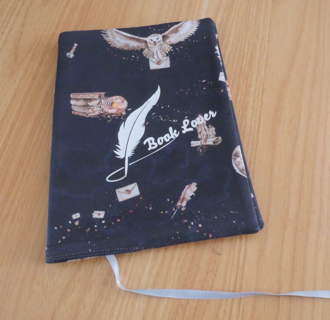 Couvre-livre fait main en tissu noir illustré fantasy avec chouettes, plumes et inscription "Book Lover", marque-page satin blanc
